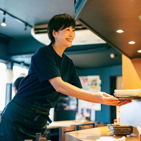 料理をさげる女性スタッフ